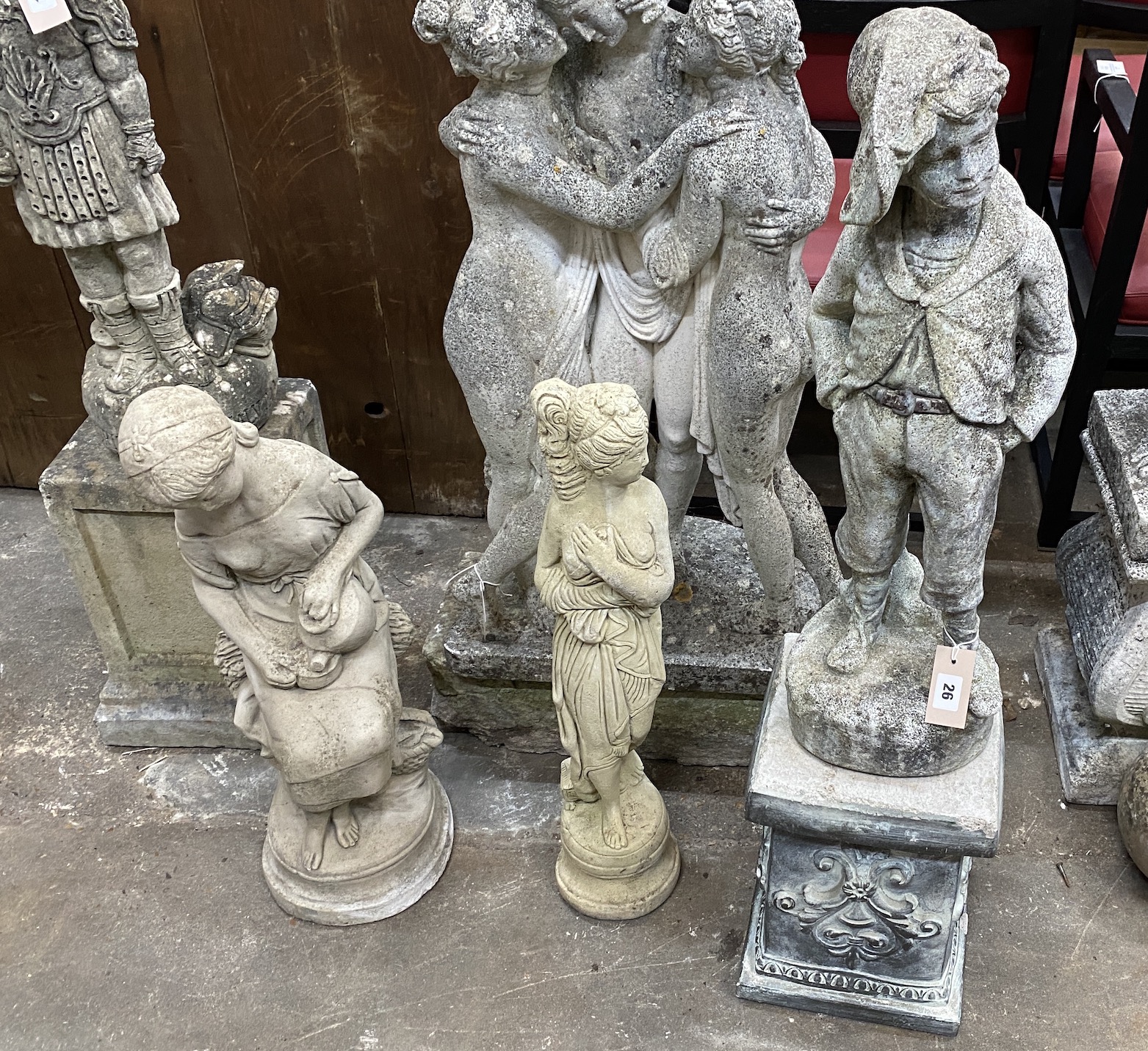 Three reconstituted stone garden statues, one on a square plinth, tallest 99cm